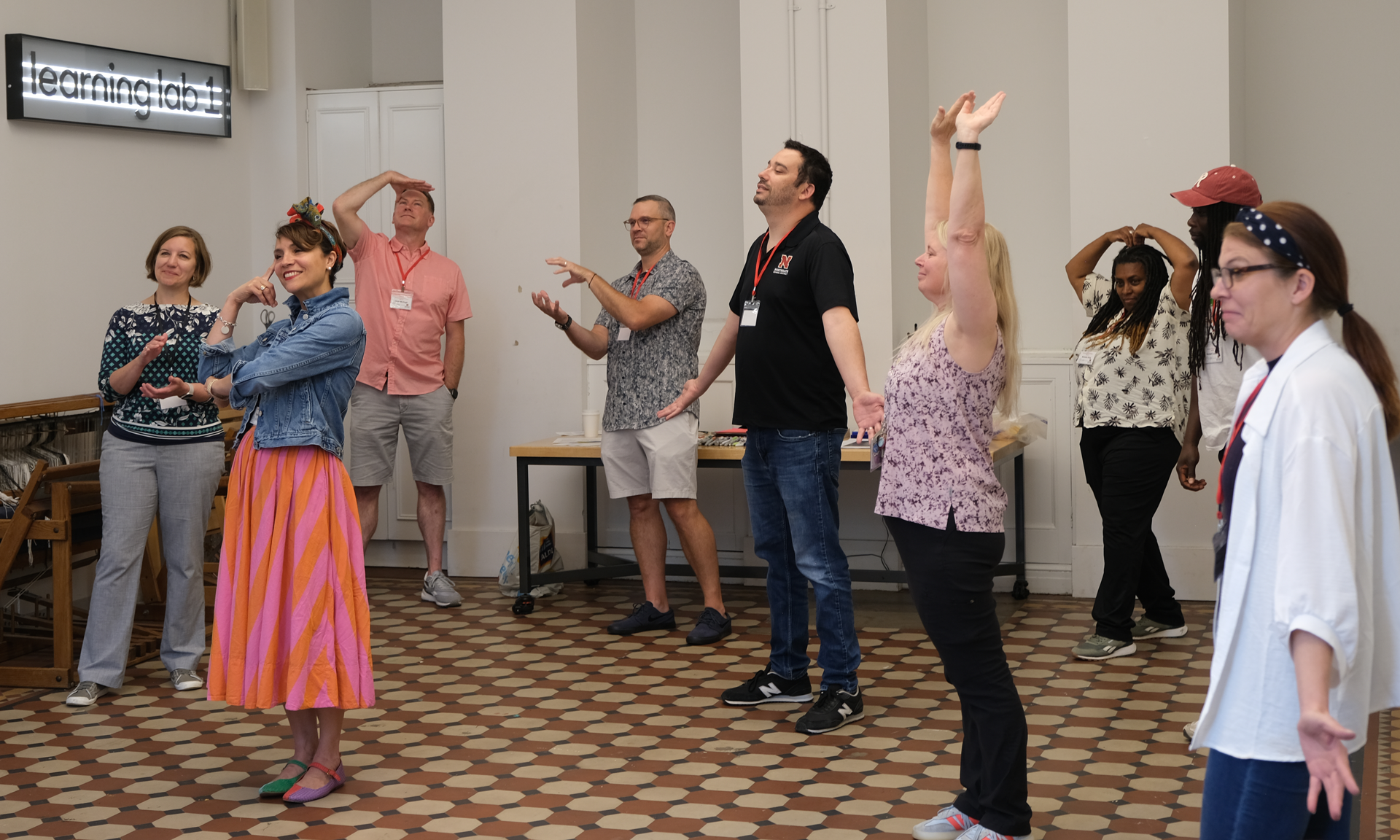 Home A group of people take on poses expressing their learning values as part of an embodied workshop.
